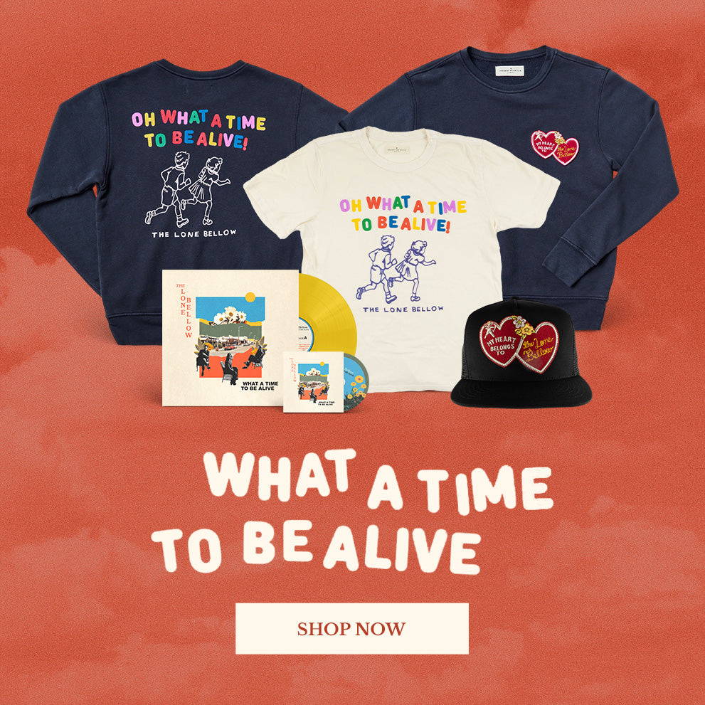 Collection of 'What a Time to Be Alive' merchandise including t-shirts, sweatshirts, and a hat on a red background.